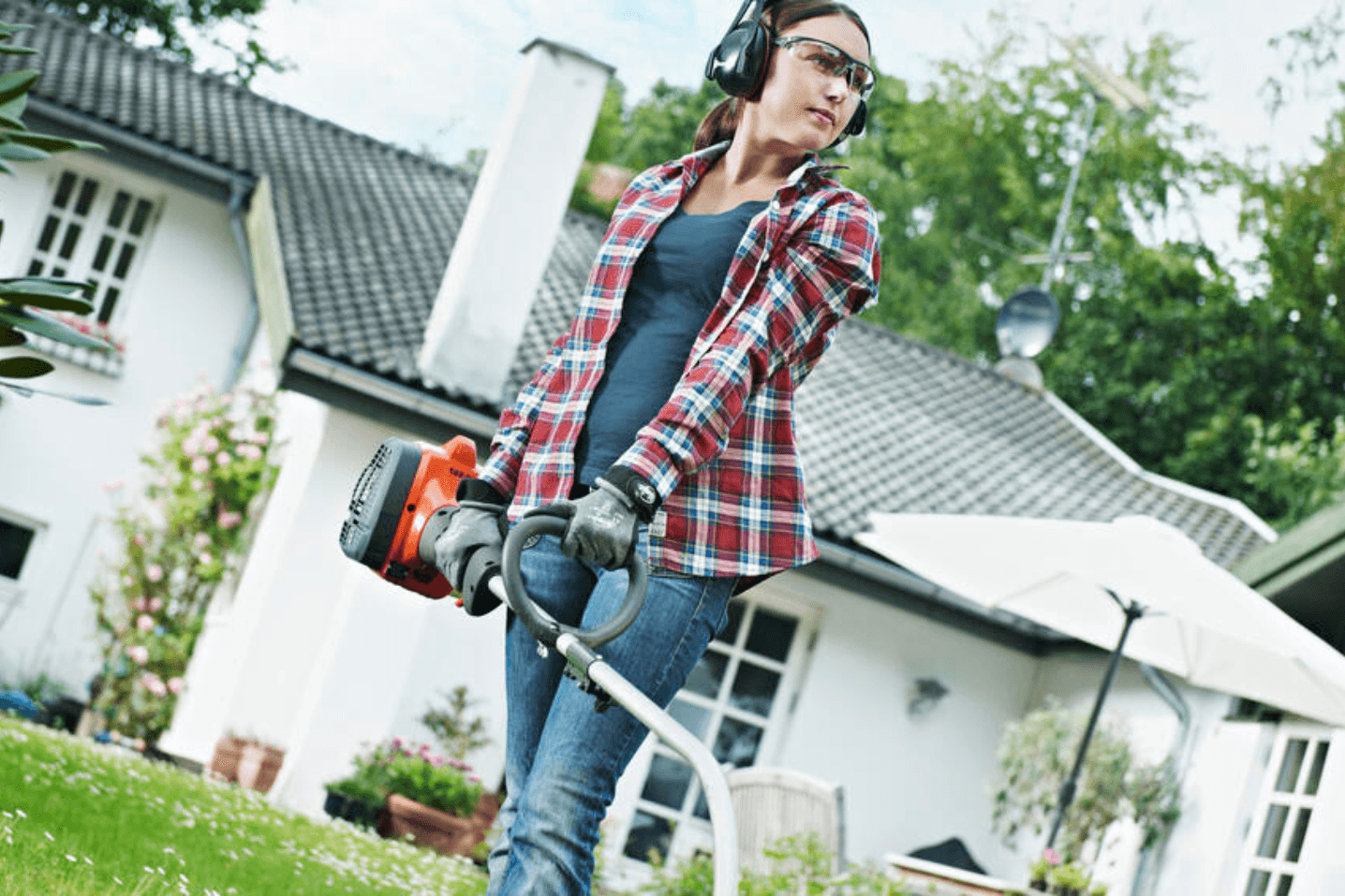 woman in backyard with brushcutter